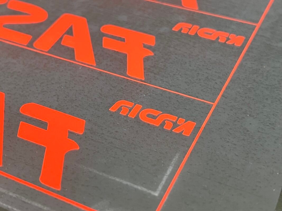 Orange high-density silicone logo printed on black fabric